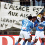 Le Strasbourgeois Guy Mancamba Luyindula (C) est félicité par ses coéquipiers Habib Beye (G) et Pierre Njanka Beaka (D) après avoir marqué le 1er but de son équipe le 03 décembre 1999 contre Bastia, une banderole "L'Alsace est aux Alsaciens..." déployée